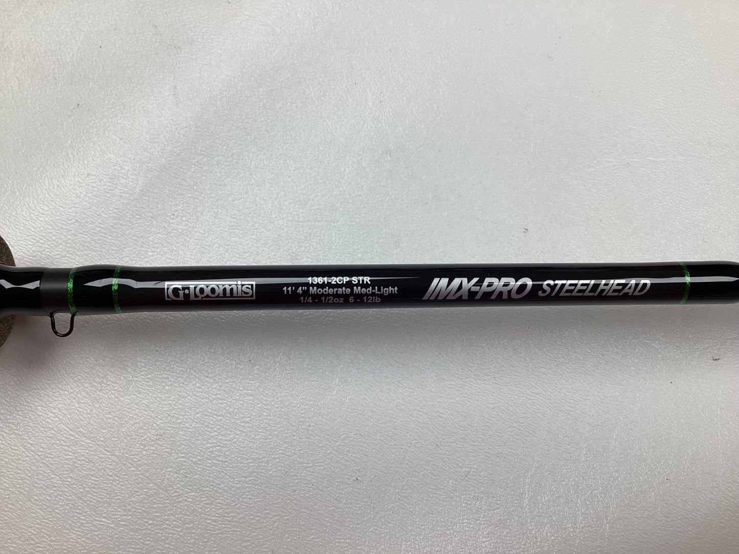 A close-up of a black G. Loomis IMX-PRO Steelhead Centerpin Rod labeled 1361-2CP STR, showing specs: 11'4" Medium Light, Used - Mint Condition.