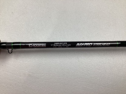 A close-up of a black G. Loomis IMX-PRO Steelhead Centerpin Rod 13200-4CP STR 11'0" Ultra Light (Used, Mint Condition), with text shown on the rod, against a white textured background.