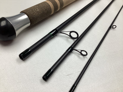 Close-up of a G. Loomis IMX-PRO Steelhead Centerpin Rod 13200-4CP STR 11'0" Ultra Light, used in mint condition, disassembled with cork handle, metal reel seat, and three rod sections with guides on a white surface.
