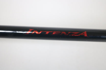 A close-up of a black Shimano Intenza NTZC711MHG 7'11" Medium Heavy Glass used casting rod in excellent condition, showing "INTENZA" in red on its surface—possibly from the Rod and Reel Trade-In Program.