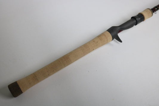 A close-up of the G. Loomis IMX PRO 862C BJR 7’2” Medium Used Casting Rod in mint condition, featuring a cork handle and black reel seat, positioned diagonally on a plain white background.