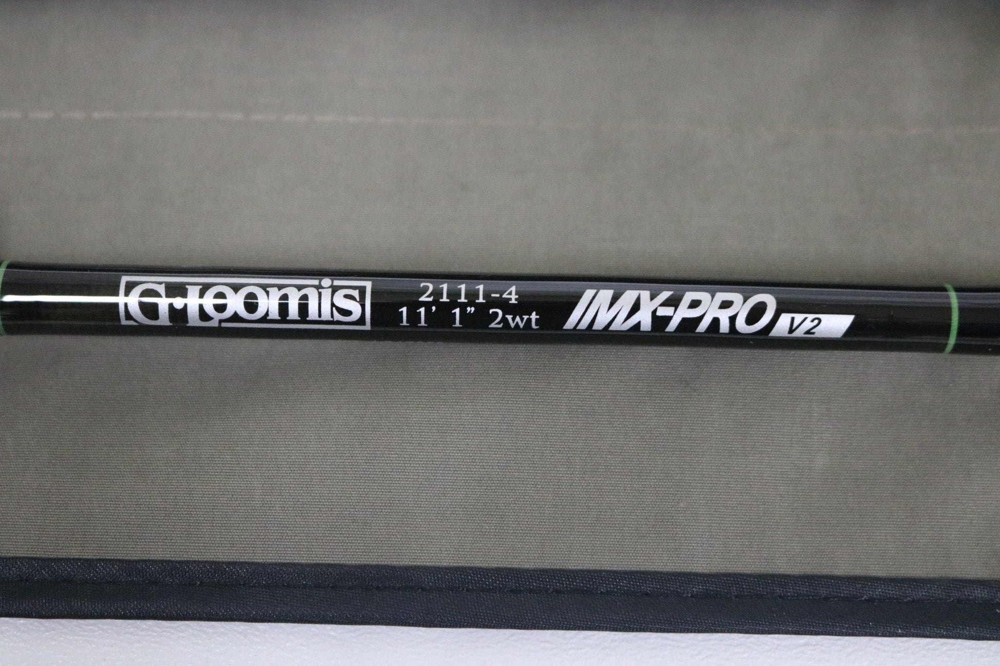 A close-up of a G. Loomis IMX-PRO V2 Shortspey 2111-4 11'1" #2 used fly rod in mint condition, set against a beige background—great for those interested in used gear or our Rod and Reel Trade-In Program.