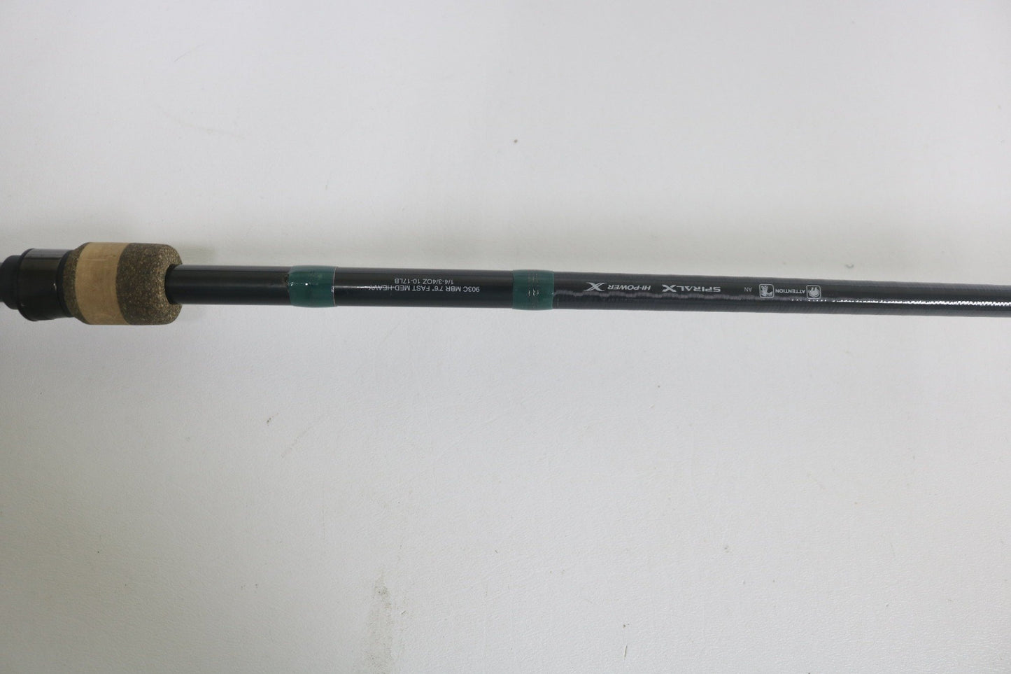 A close-up of the G. Loomis Conquest CNQ 903C MBR 7'6" Medium Heavy Used Casting Rod in good condition, featuring a cork handle, black reel seat, and visible specs on a plain white background—ideal for those upgrading gear or exploring trade-in options.