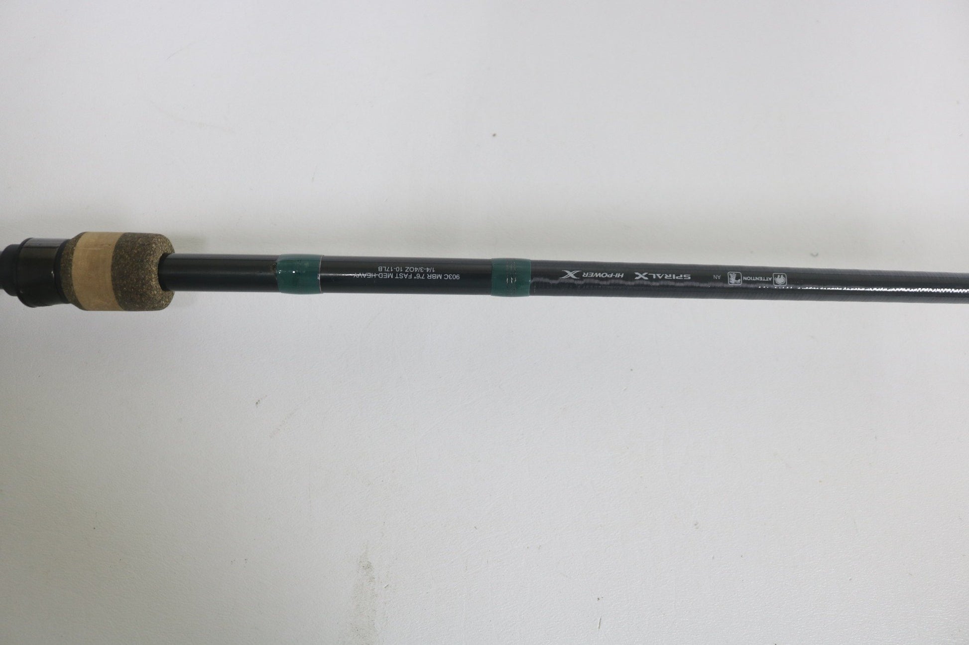 A close-up of the G. Loomis Conquest CNQ 903C MBR 7'6" Medium Heavy Used Casting Rod in good condition, featuring a cork handle, black reel seat, and visible specs on a plain white background—ideal for those upgrading gear or exploring trade-in options.