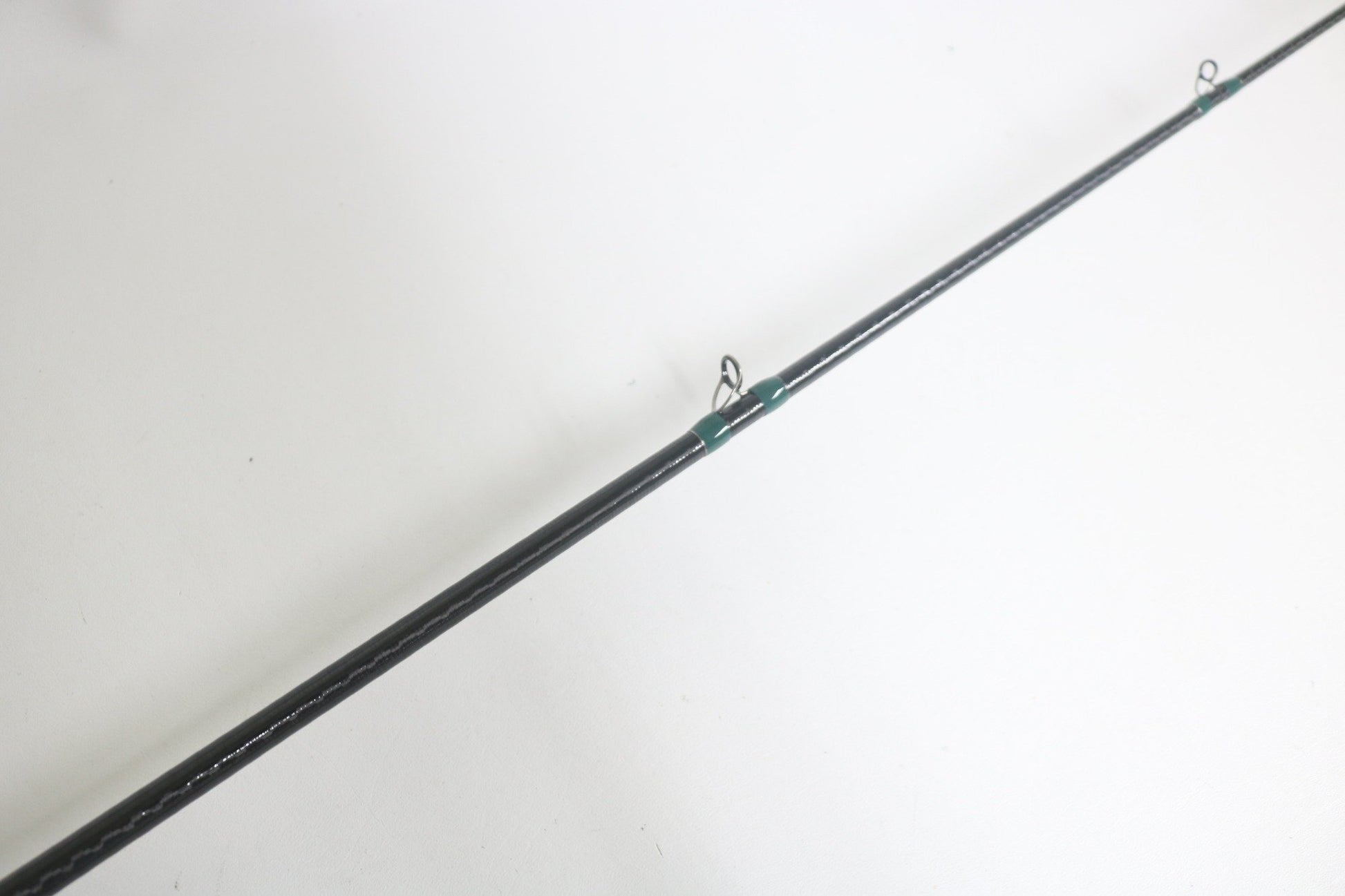 A close-up of the G. Loomis Conquest CNQ 903C MBR 7'6" Medium Heavy Used Casting Rod in good condition, shown diagonally on a white background—perfect for upgrading your gear with our trade-in program for store credit.