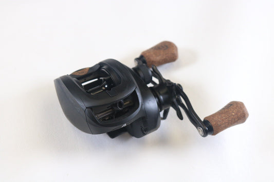 A 13 Fishing Concept A2 A2-7.5-LH Used Casting Reel in very good condition sits on a white surface, showcasing its compact design and visible gears—ideal for used gear shoppers or those interested in our rod and reel trade-in program.
