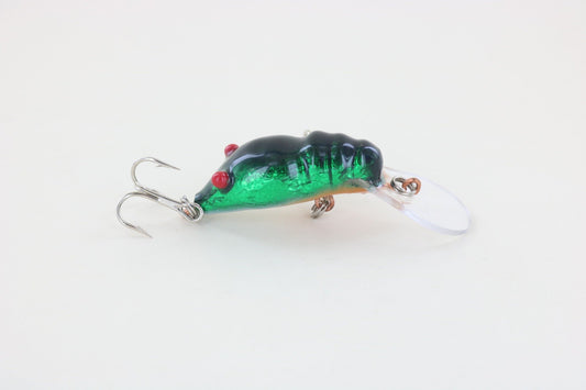 The WE Baits Red Eye Craw Green Foil is a green and black fishing lure with red eyes and two treble hooks from WE Baits, displayed on a plain white background.