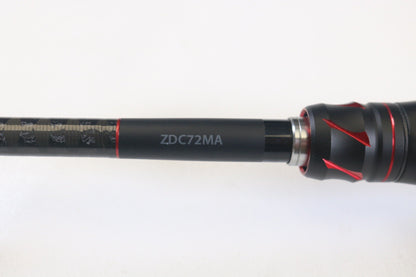 Close-up of a Shimano Zodias ZDC72MA 7'2" Medium Casting Rod featuring red accents on a sleek black shaft, set against a white background. Trade in your gear for possible store credit via our Rod and Reel Trade-In Program.