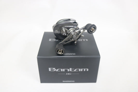 A Shimano Bantam BANTAM150HGA 7.1:1 casting reel in excellent used condition sits atop its black box marked "Bantam HG Shimano" in white, set against a plain white background.
