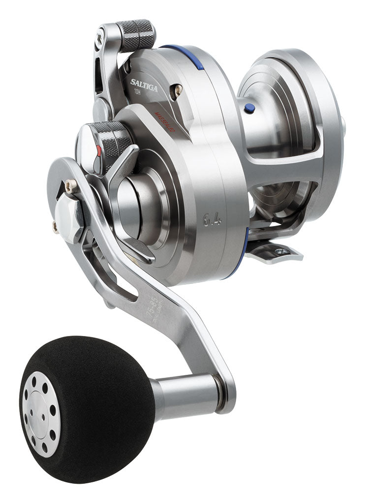 Close-up of the Daiwa Saltiga 6.4:1 Star Drag Convention Reel SASD10H, featuring a silver finish, black handle grip, star drag system, precision engineering with Magsealed ball bearings, and an array of knobs and levers for enhanced performance.