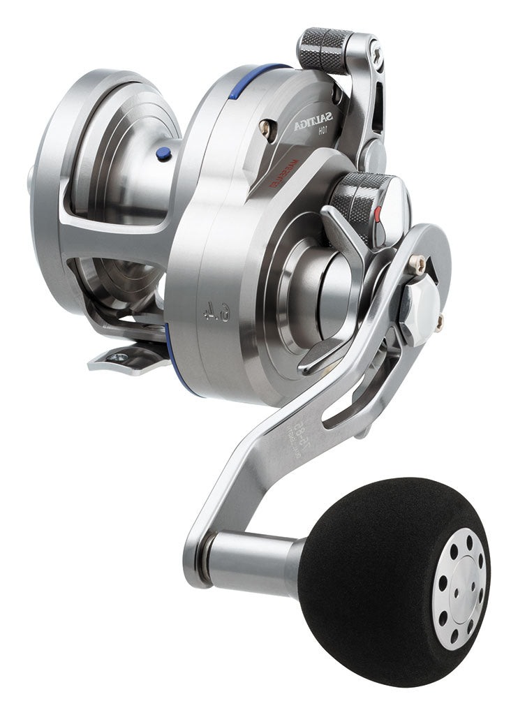 The Daiwa Saltiga 6.4:1 Star Drag Left Hand Convention Reel SASD10HL is a sleek metallic fishing reel featuring multiple knobs and adjustments with a black grip handle, partially in shadow. Its subtle Daiwa branding and Magsealed ball bearing ensure top-notch performance.