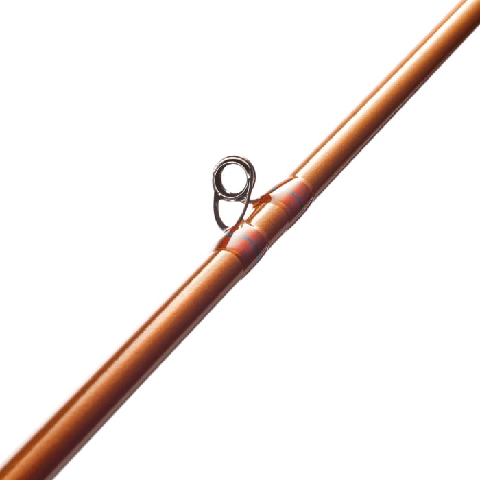 An up-close view of an orange casting rod with a silver guide loop displays the St. Croix Legend Glass 6'10" Medium Heavy Casting Rod by americanlegacyfishing, which features a shiny finish and a bright red ring near the guide, highlighting IPC mandrel technology for improved performance.