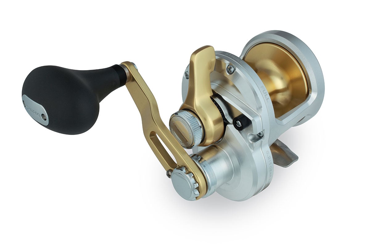 A close-up of the Shimano Talica TAC8 Lever Drag Reel by Shimano, featuring a silver and gold finish, black handle, metallic components, smooth drag system, and a durable design ideal for heavy-duty fishing.