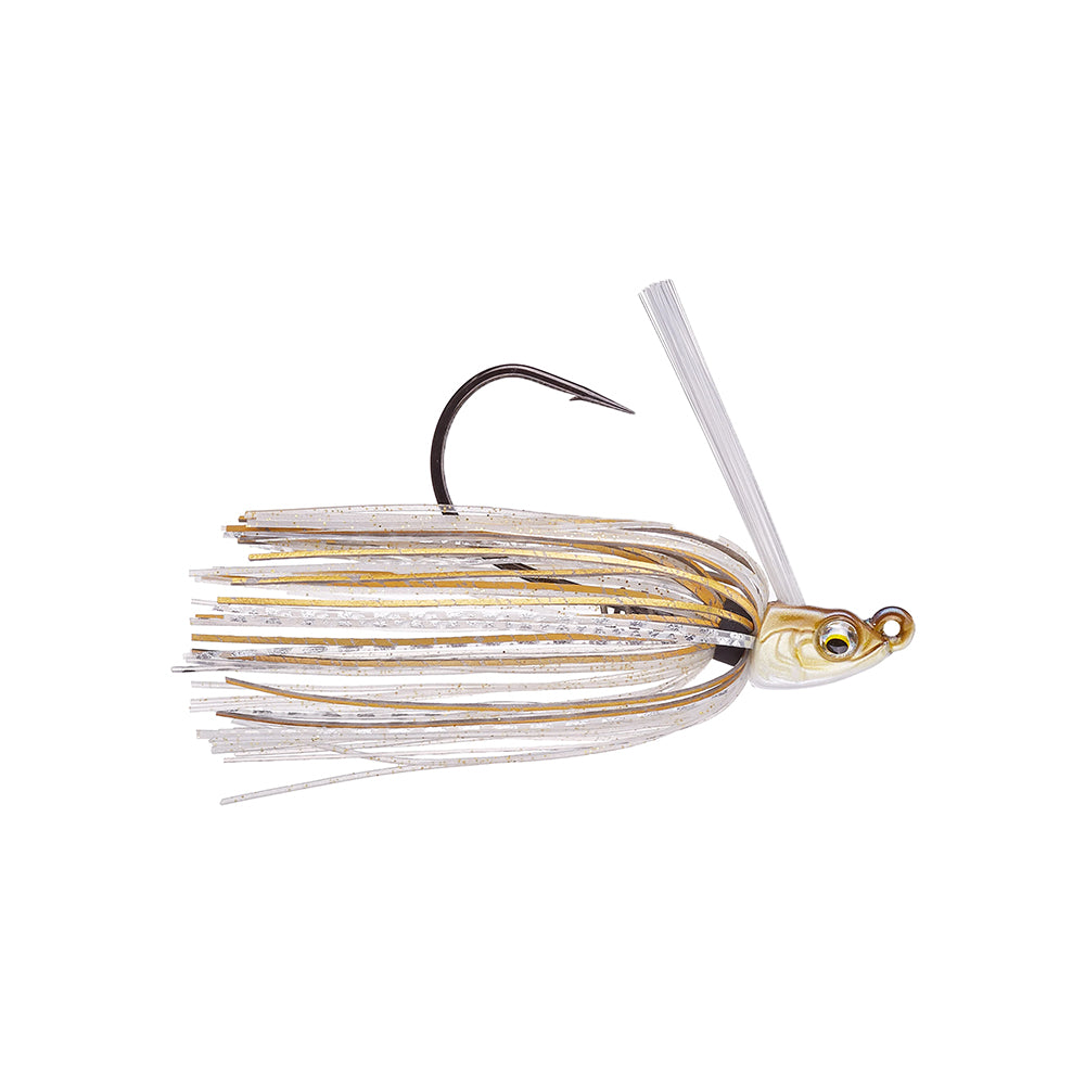 The 6th Sense Divine Swim Jig by 6th Sense features a realistic fish-shaped head, lifelike painted eyes, gold/silver silicone skirt strands, a large hook with weed guard, making it an effective fishing lure for attracting fish.