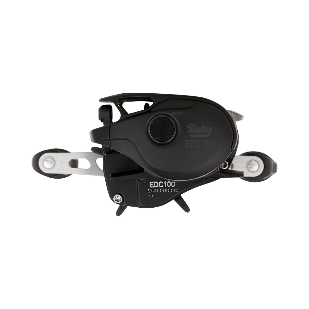 Close-up of a Bates Fishing Co. EDC 100 Casting Reel 7.1:1 RH (BREDC100RH711) in black and silver, showing detailed levers and dials, photographed against a plain white background.