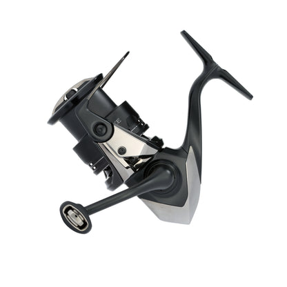 The Shimano Exsence B Spinning Reel 2500XGB (25EXS25XGB) features a sleek black and silver design with a 6.4:1 gear ratio, ideal for finesse fishing, and is shown on a white background.