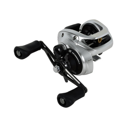 The Shimano Tranx 400 B Casting Reel 5.8:1 RH (TRX400B) by Shimano is a low-profile, silver and black reel with dual handle knobs, a compact body, and visible spool, all shown on a white background.
