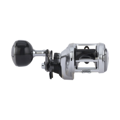 A Shimano Tranx 400 B Casting Reel 7.6:1 LH Power Handle (TRX401HGB) in silver and black, featuring a round power handle, is shown from the side on a white background.