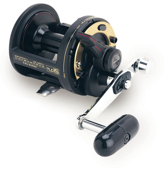 A close-up of the Shimano TLD 15 Lever Drag Fishing Reel by Shimano, featuring a black and gold design with a silver crank handle and large black grip, set against a white background.