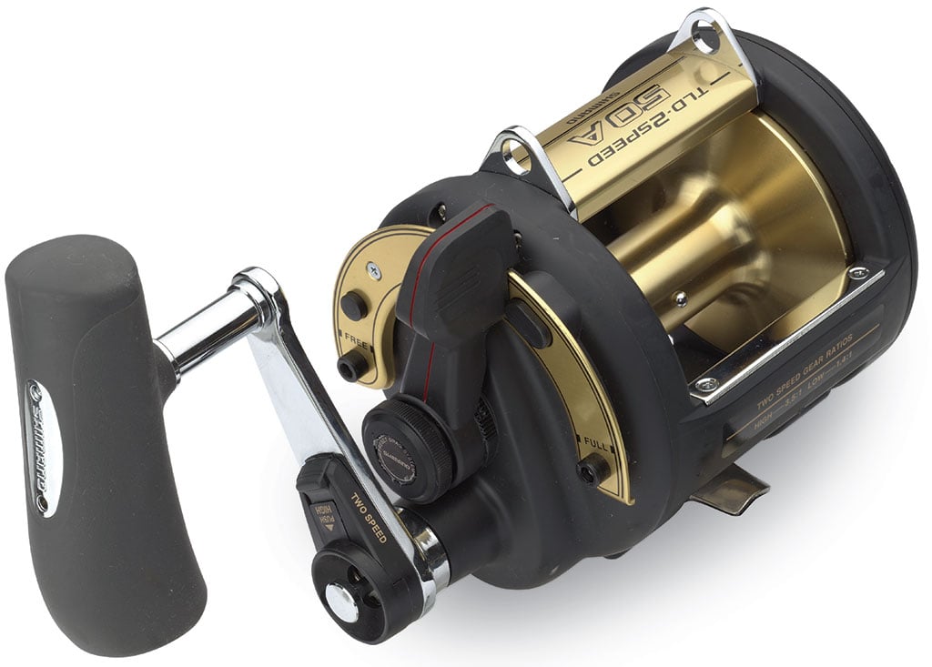 The Shimano TLD 2-Speed 50IIA Lever Drag Fishing Reel boasts a robust black and gold design with a sturdy handle and metal accents. Featuring A-RB Bearings, adjustment knobs, and engravings, it's ideal for deep-sea or heavy-duty fishing.
