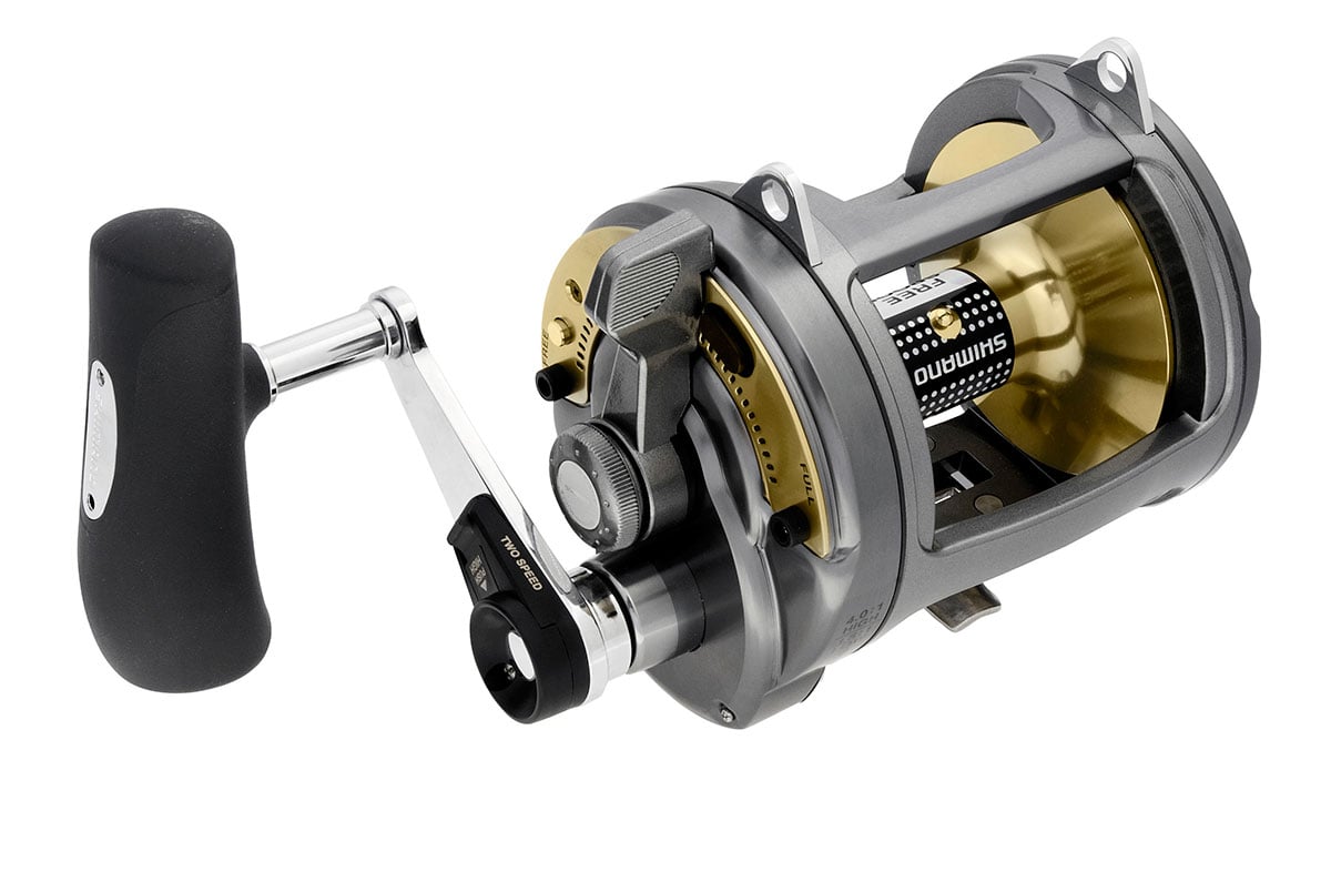A close-up of the Shimano Tyrnos 50IILRS 2-Speed Lever Drag Fishing Reel by Shimano, in metallic gray and gold with a black handle, displays its advanced gear system against a white background.